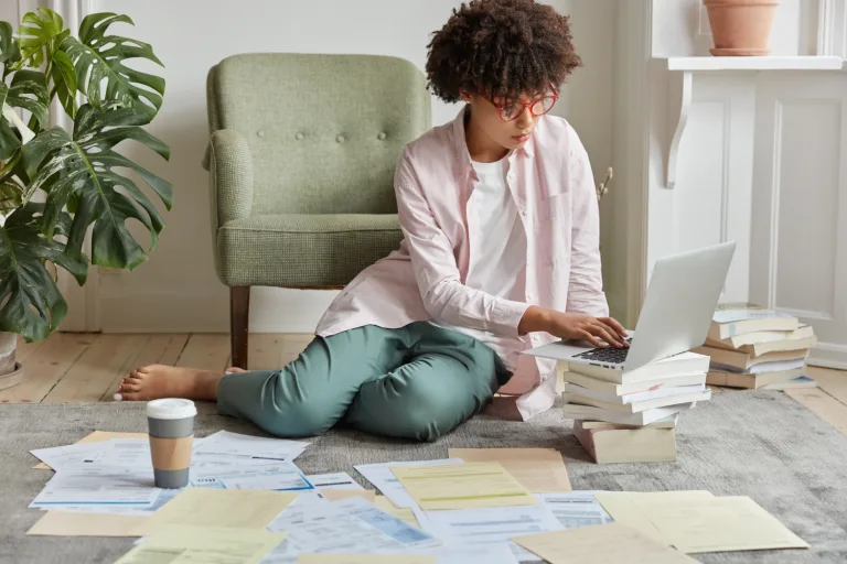 Jeune femme en recherche d'un logement sur son ordinateur.